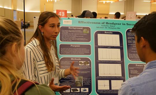 Students shows her project about headgear in soccer to students 
