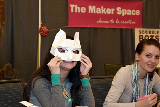 woman holding up paper fox mask