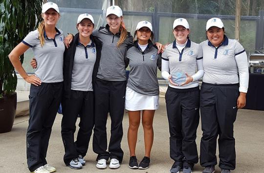 women's golf holds second place trophy