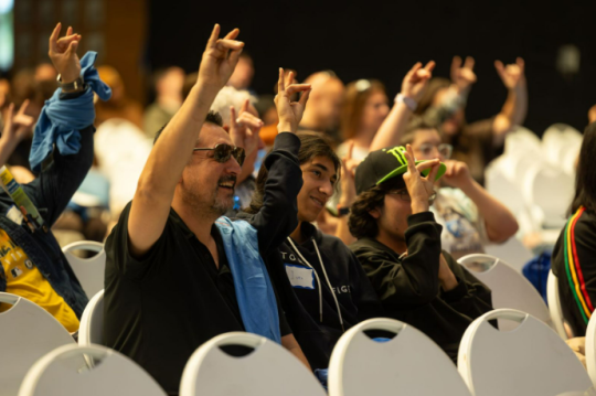 People sitting seats and cheering during a Decision Day presentation