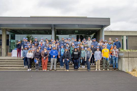 A large group of people posing for a group photo in front of the WSLC