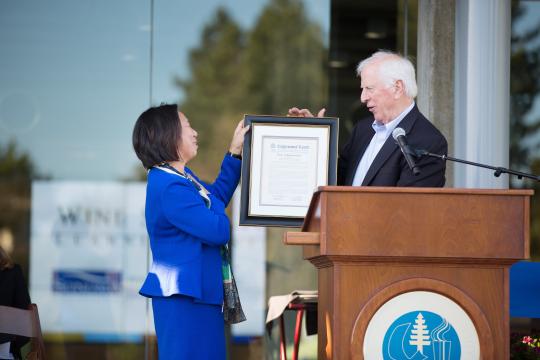 Rep. Mike Thompson hands President Judy K. Sakaki a copy of a Congressional Resolution honoring Sonoma State for the opening of the WSLC.